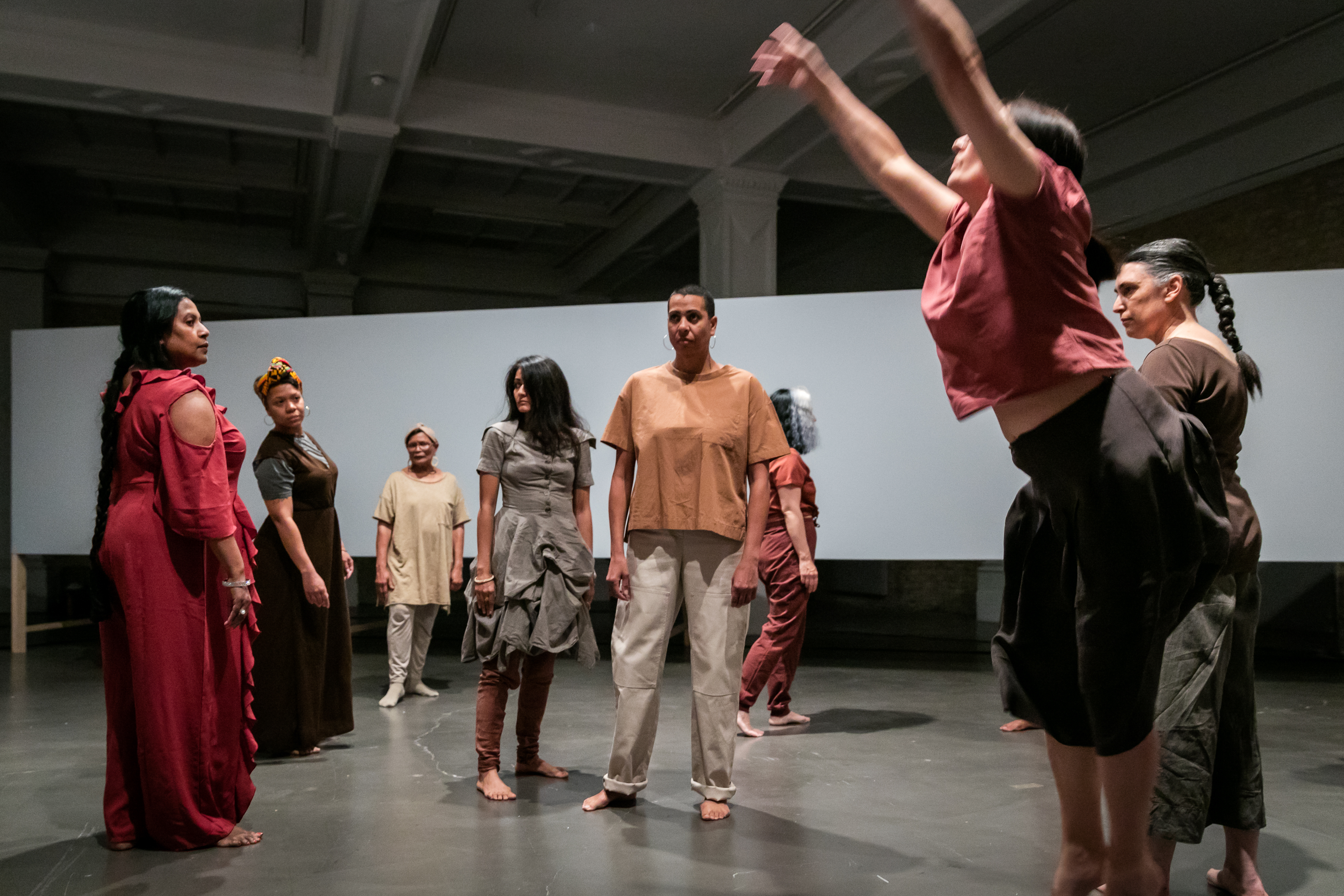 Women dancing at a performance in a gallery.