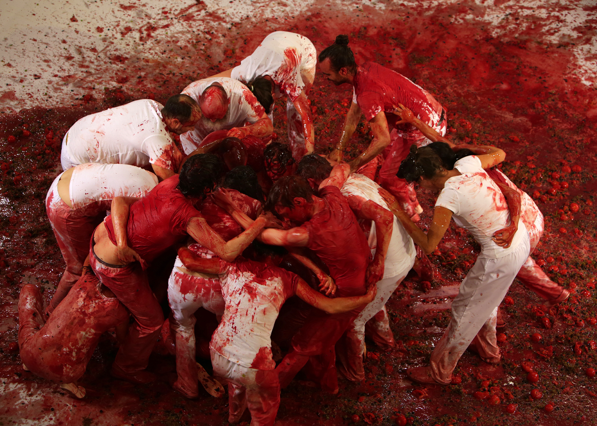 People wearing white in a circle covered in red paint