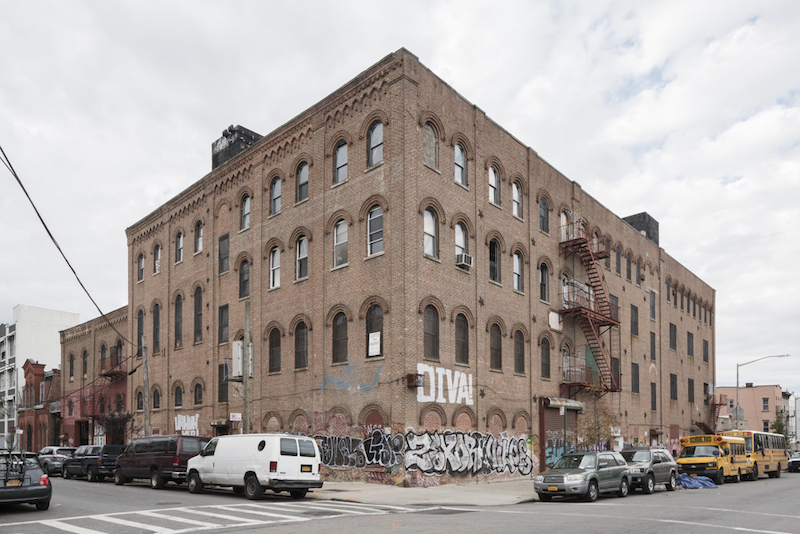 The front of a brick building covered in graffiti