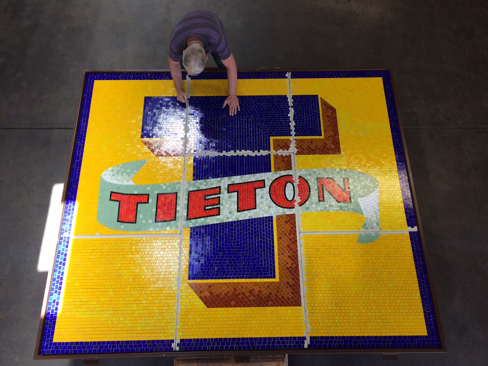 colorful yellow, blue, and red mosaic sign with the word "Tieton" overlaying a large letter T