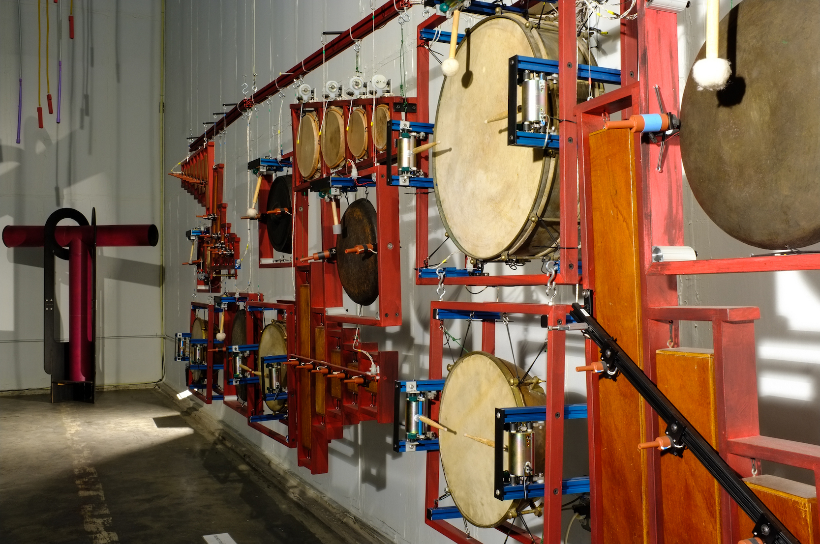 artwork-like wall of instruments hanging up by strings