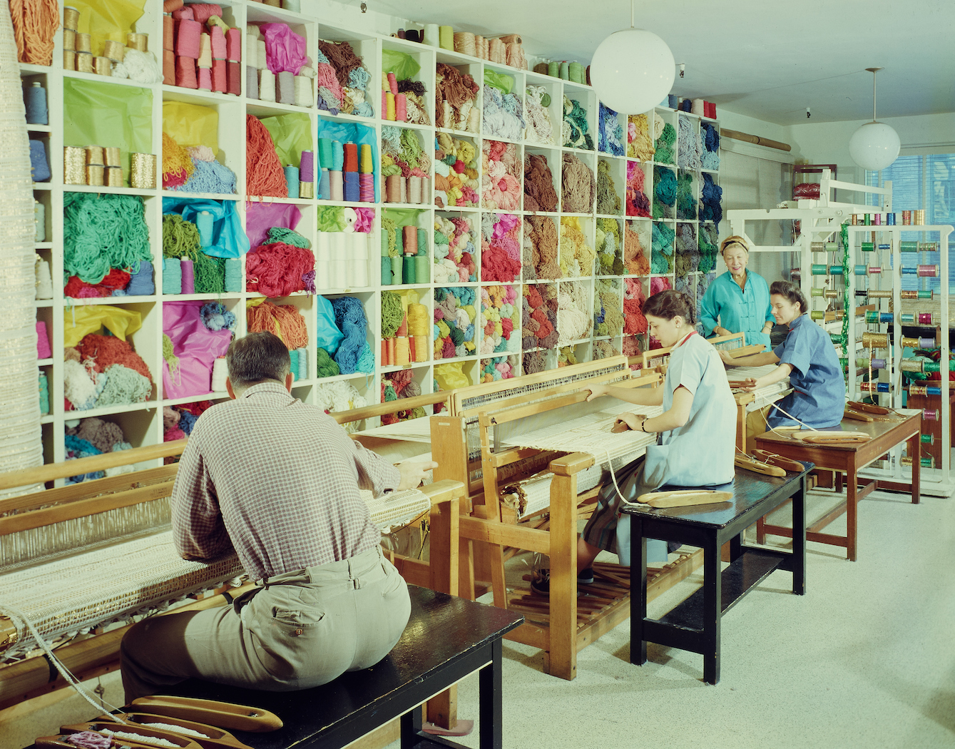 liebes and colleagues weaving at looms in colorful design studio