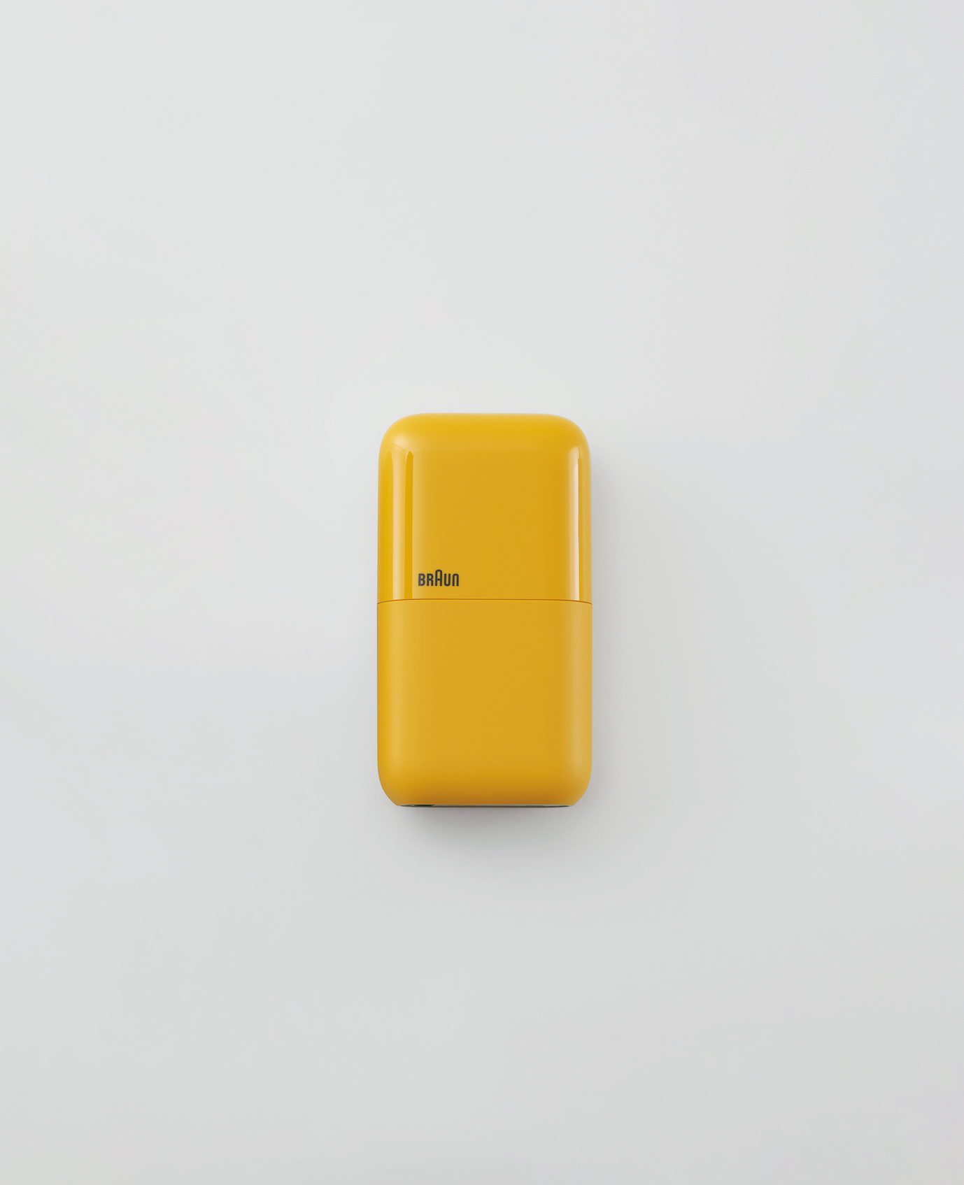 small rectangular yellow pocket shaver against plain light background
