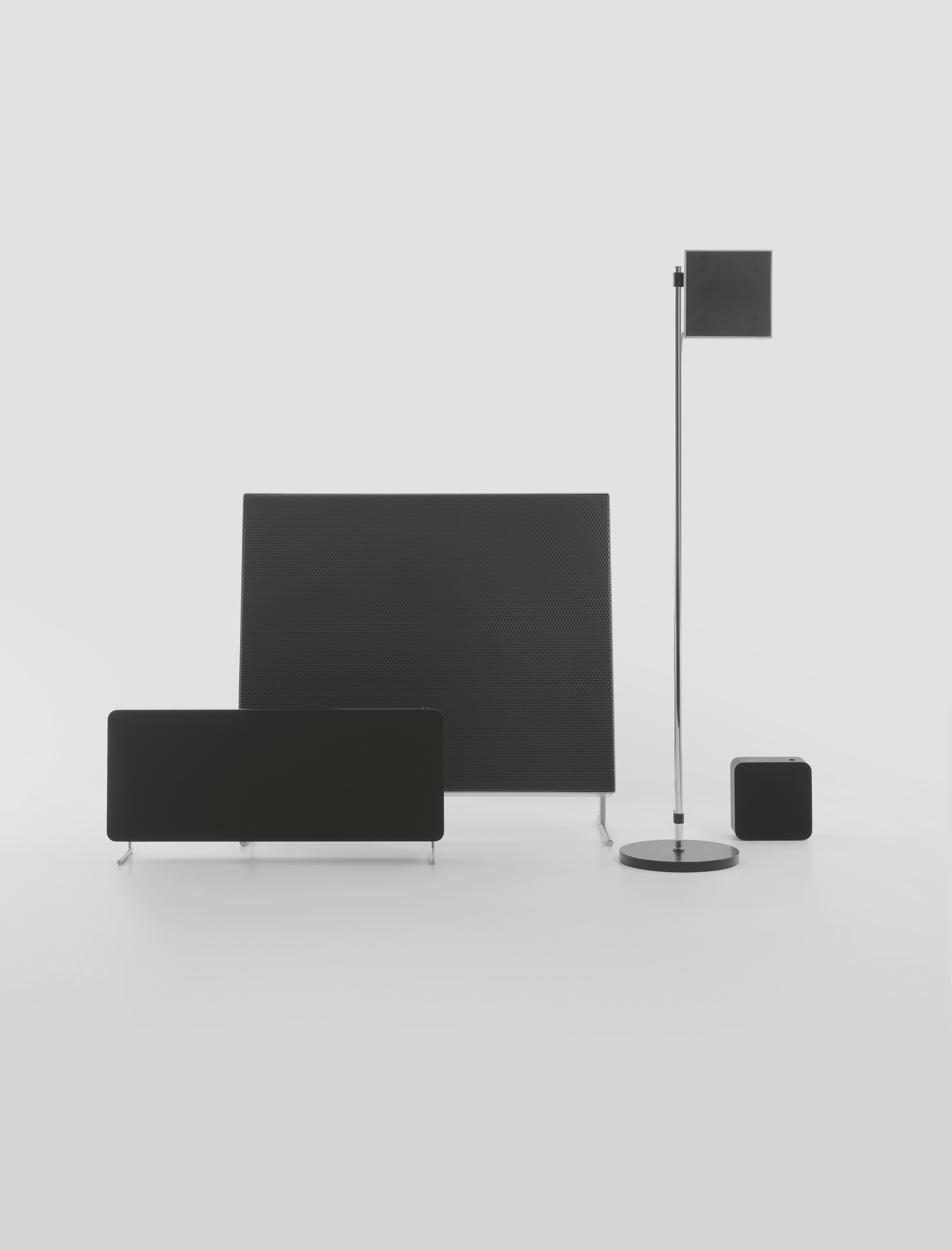 Four different shaped and sized black Braun smart speakers against a white background