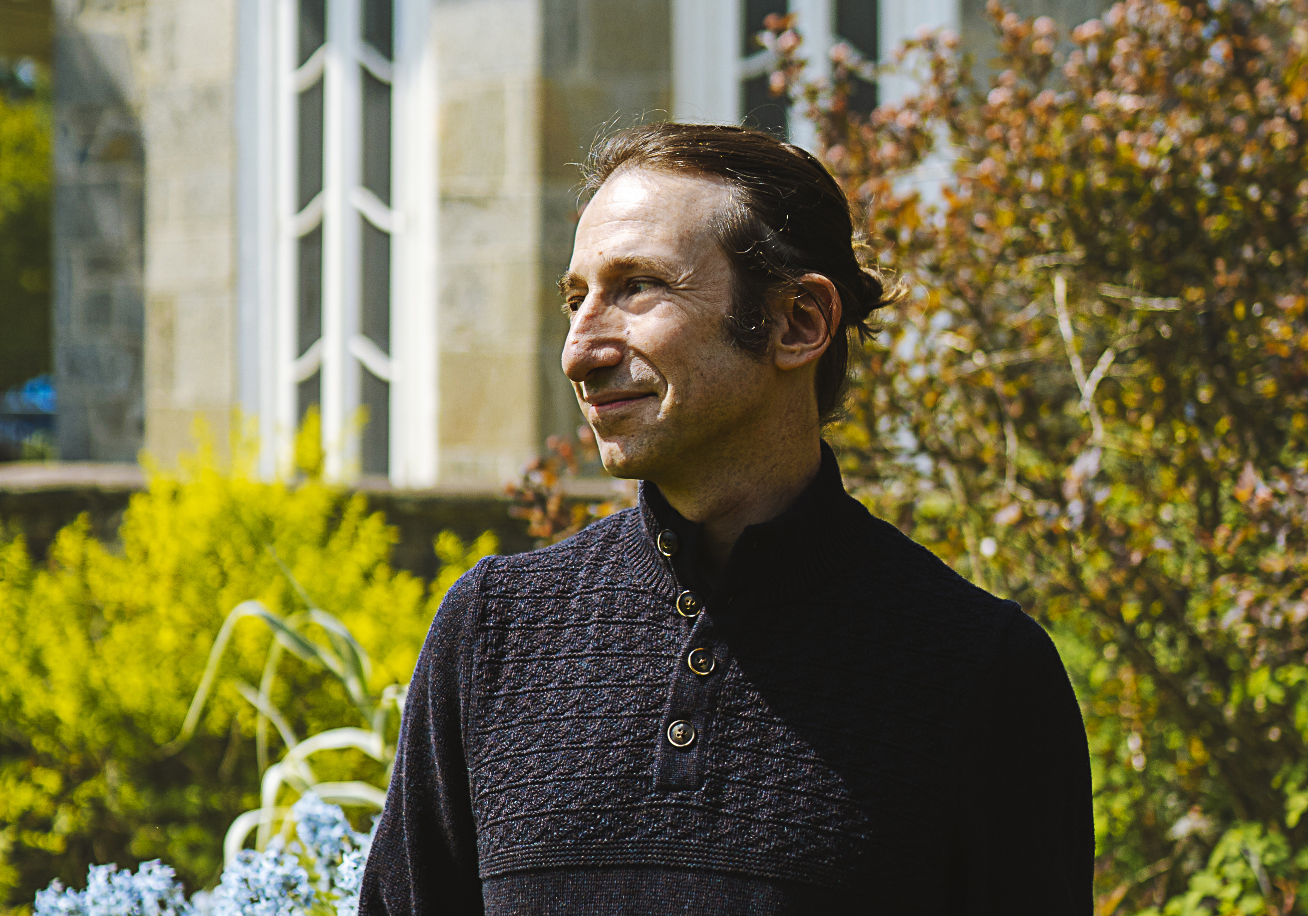 portrait of abraham burickson standing in garden outside of historic building