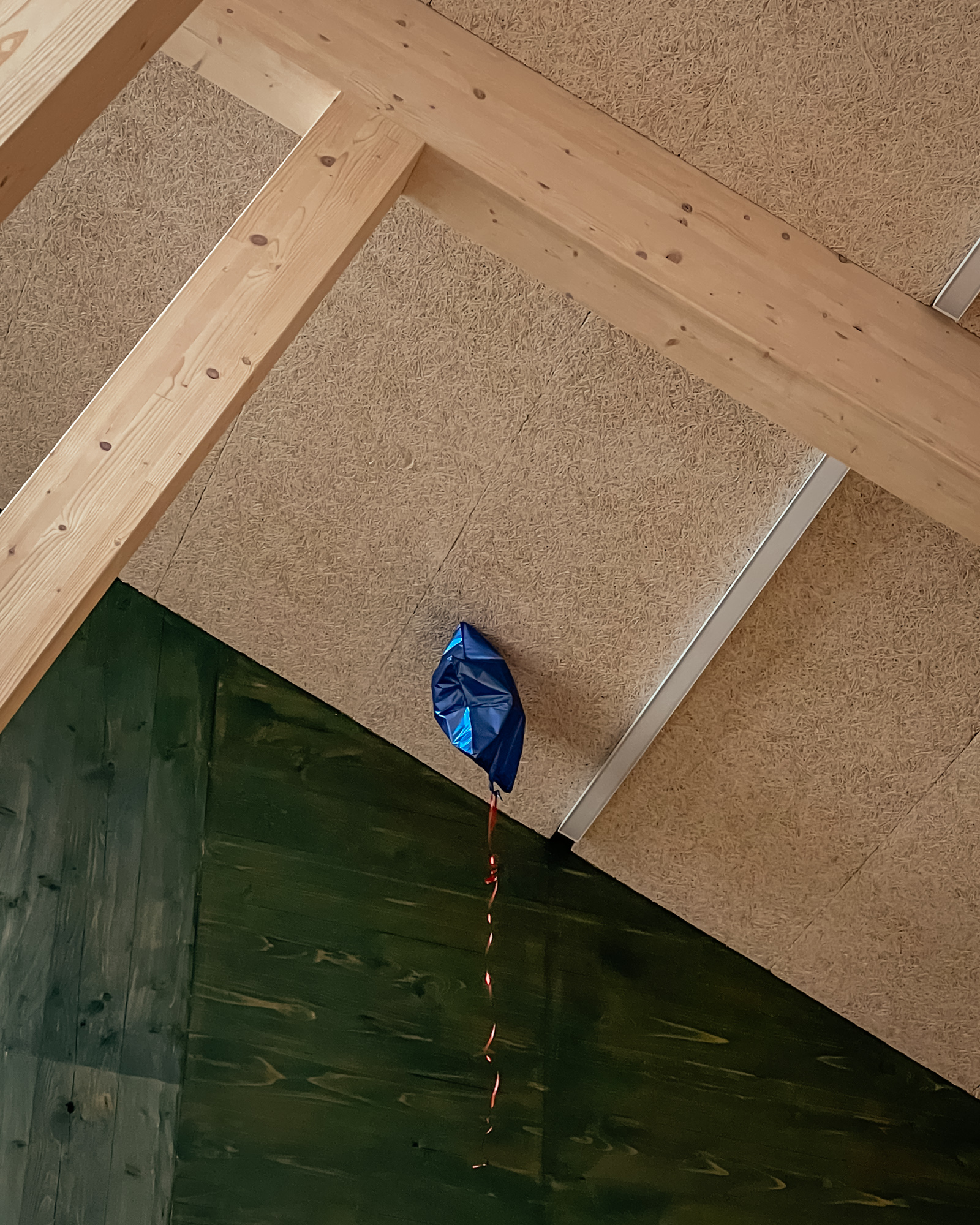 Dark blue birthday balloon that has floated up to the ceiling of the Sands End Arts and Community Centre